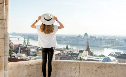 Kobieta trzymająca kapelusz i patrząca na panoramę Budapesztu