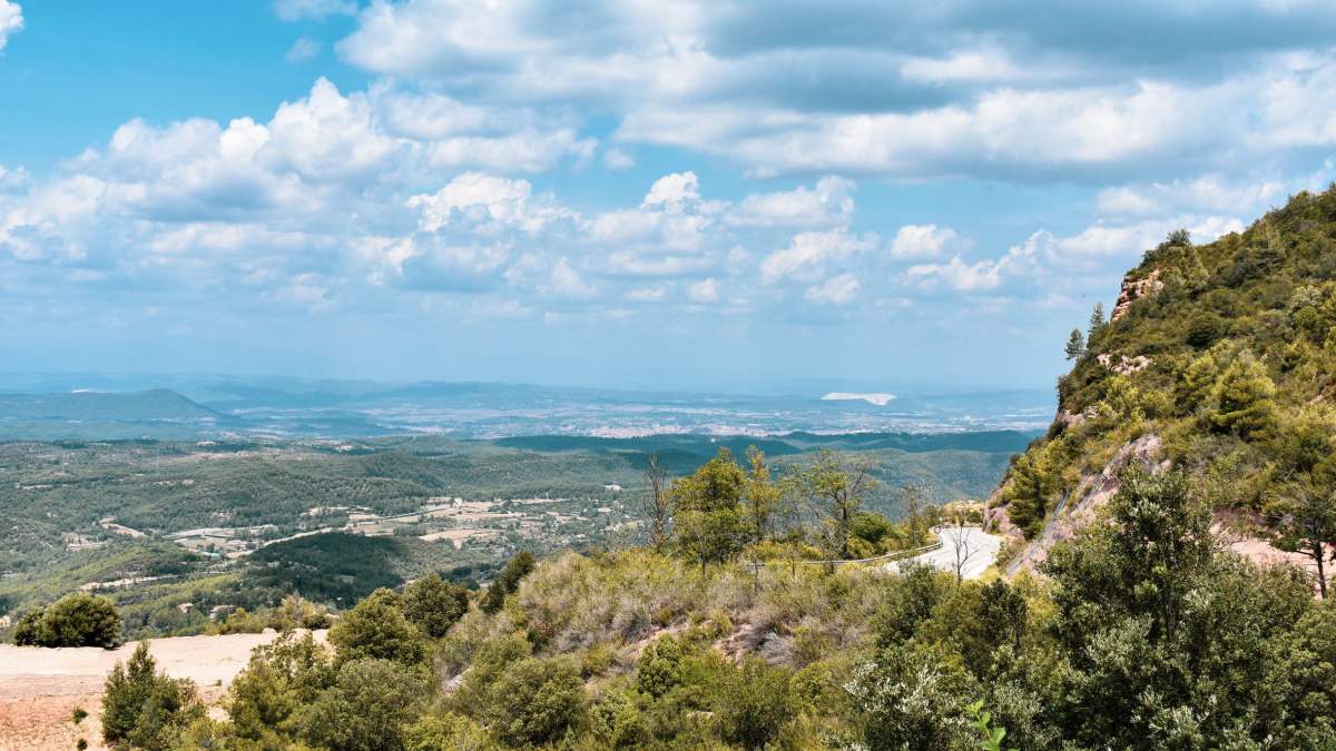 Górskie skały Montserrat i rozległa zielona dolina