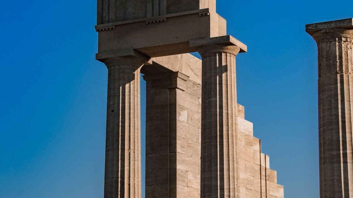 Antyczne kolumny akropolu w Lindos pod błękitnym niebem